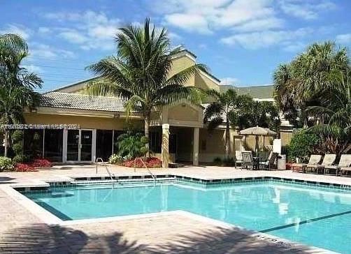 5720 Rock Island Road, Unit 385 Tamarac, FL 33319 - Photo 8 of 9 a view of a house with pool and chairs