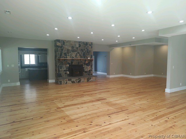 173 Lillys Neck Road Moon, VA 23119 - Photo 21 of 48 Unfurnished living room featuring light wood-type flooring and a fireplace