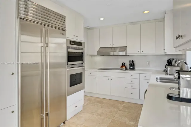 a kitchen with cabinets stainless steel appliances and sink