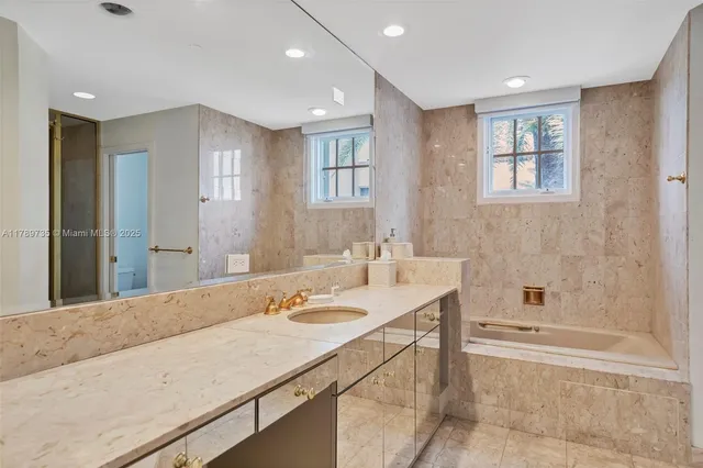 a bathroom with a tub sink and mirror