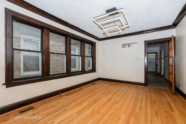 a view of a hallway with wooden floor and cabinet