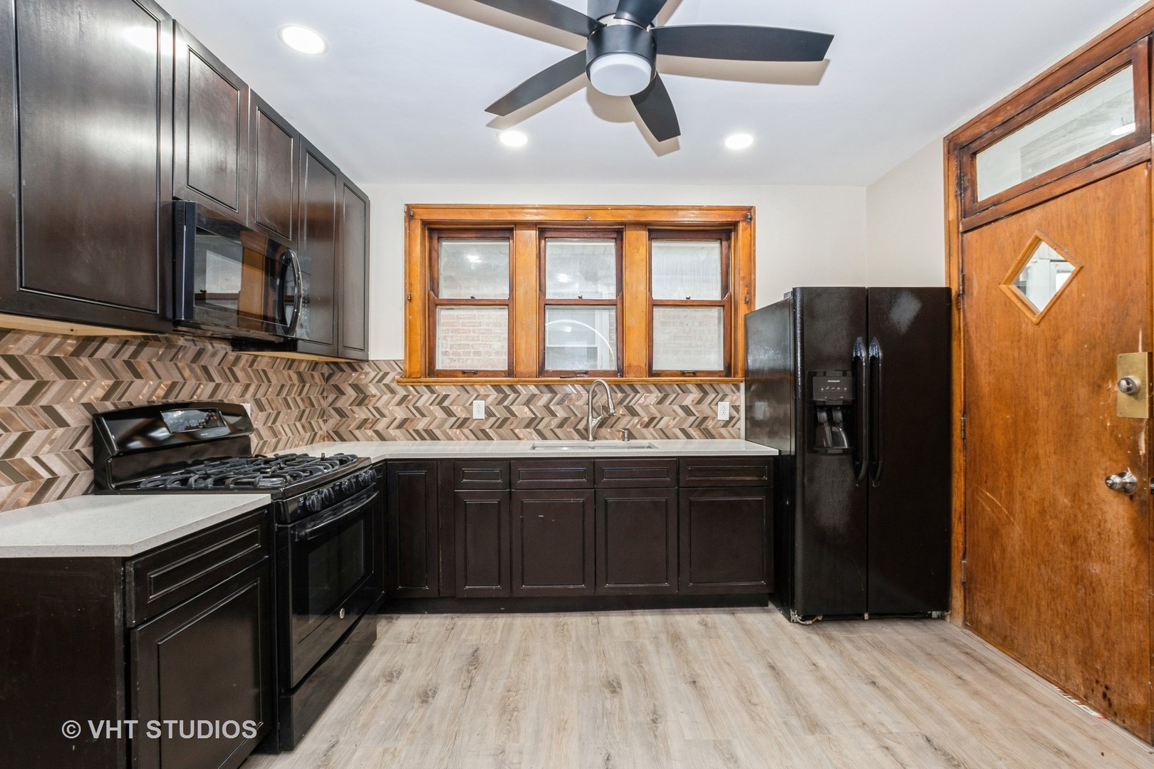 8718 South Marshfield Avenue Chicago, IL 60620 - Photo 5 of 10 a kitchen with stainless steel appliances granite countertop a refrigerator a sink and wooden cabinets