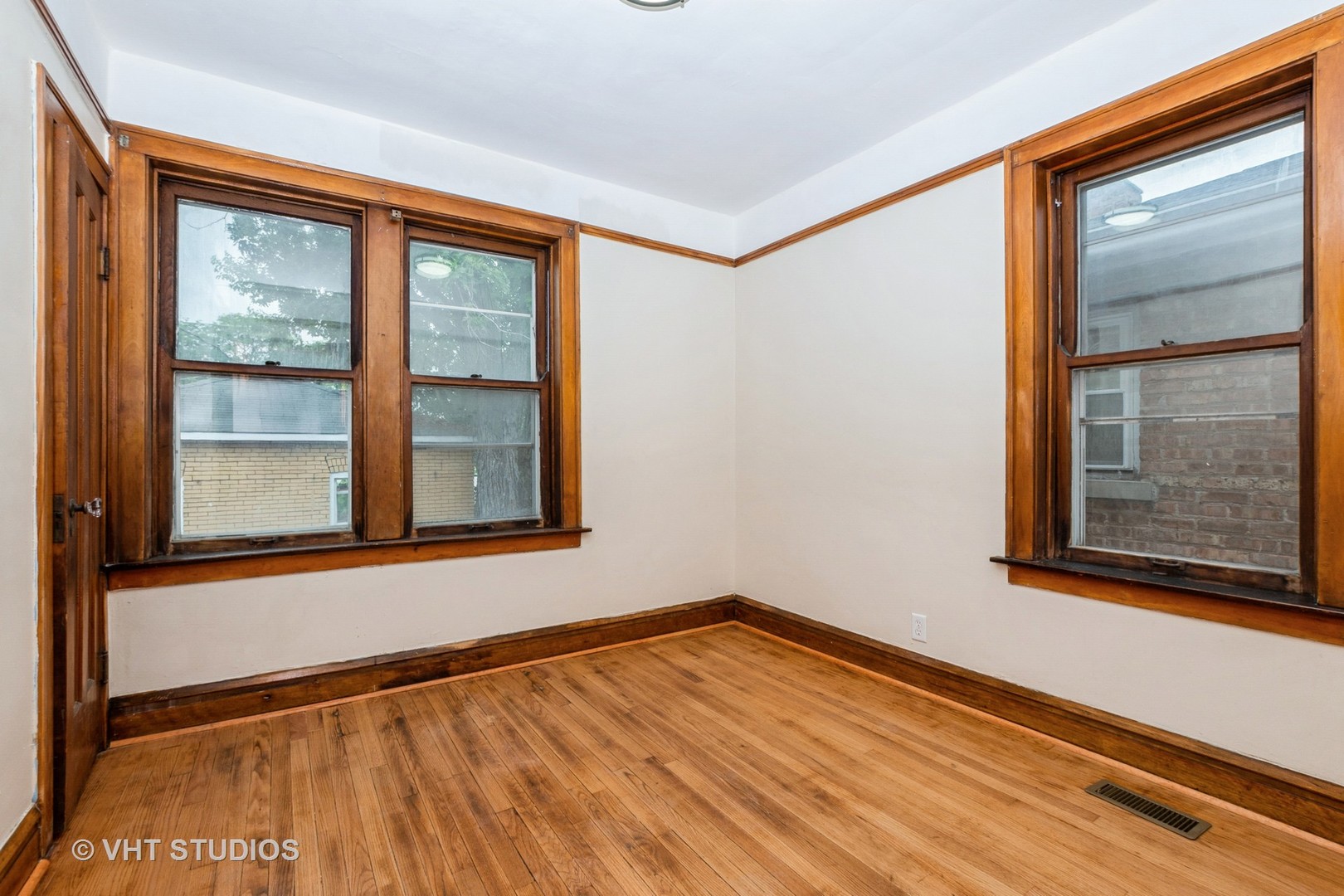 8718 South Marshfield Avenue Chicago, IL 60620 - Photo 6 of 10 a view of an empty room with a window and wooden floor