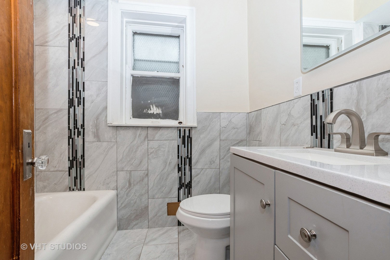 8718 South Marshfield Avenue Chicago, IL 60620 - Photo 7 of 10 a bathroom with a sink a toilet and bathtub