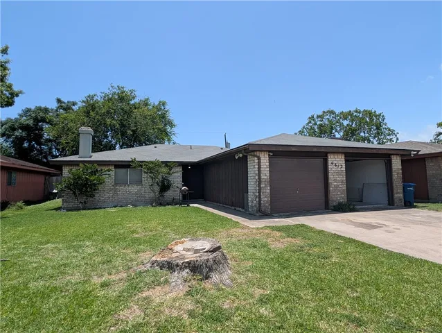 a view of a house with a yard and potted plants