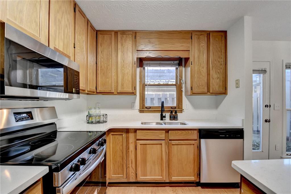 3492 Tulip Tree Lane Duluth, GA 30096 - Photo 11 of 35 a kitchen with stainless steel appliances a stove microwave and sink