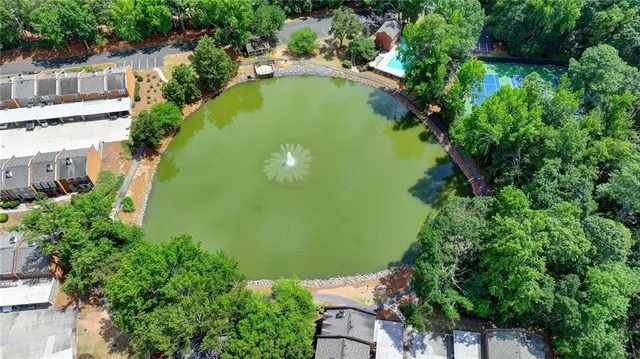 an aerial view of a house with swimming pool and trees