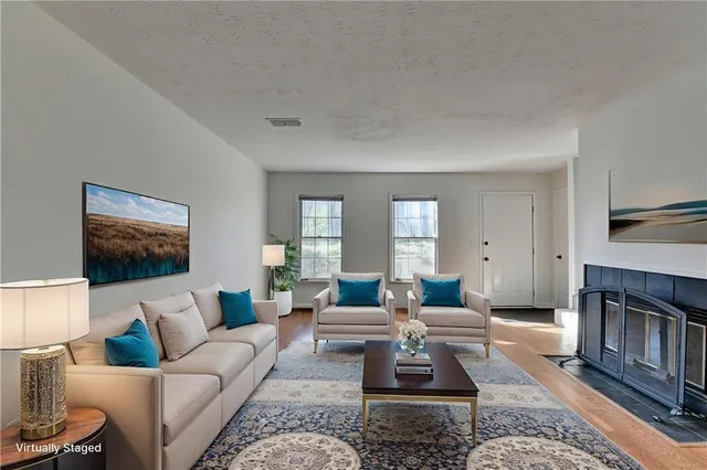 a living room with furniture wooden floor and a flat screen tv