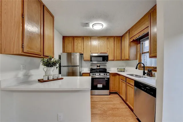 a kitchen with stainless steel appliances a sink stove refrigerator and cabinets