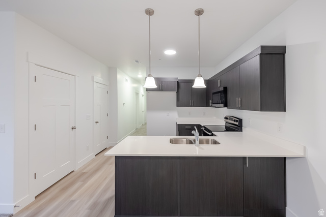 4704 Olive Avenue, Unit V204 Mapleton, UT 84664 - Photo 15 of 17 Modern kitchen featuring dark wood-finish cabinetry, light-toned countertops, and stainless steel appliances