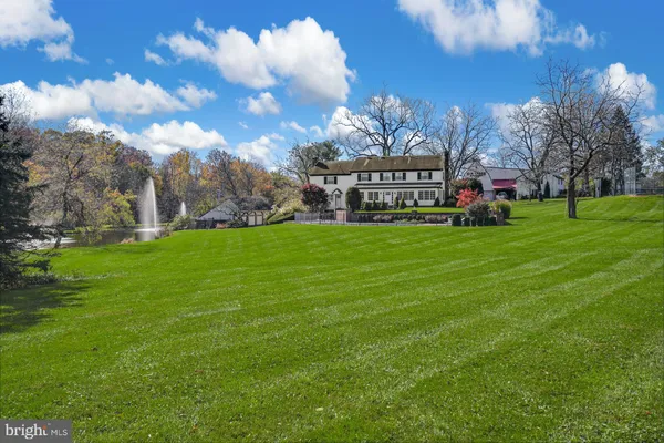 a view of a building with a big yard and large trees