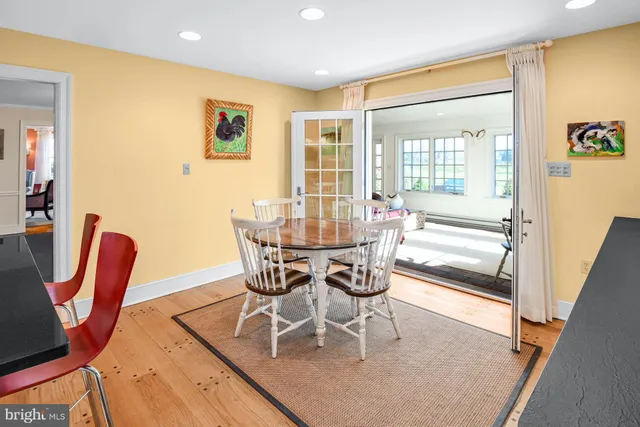 a dining room with furniture a floor to ceiling window and wooden floor