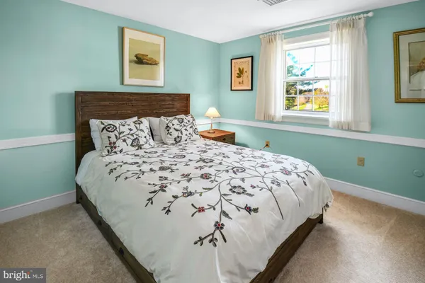 a large bed sitting in a bedroom next to a window