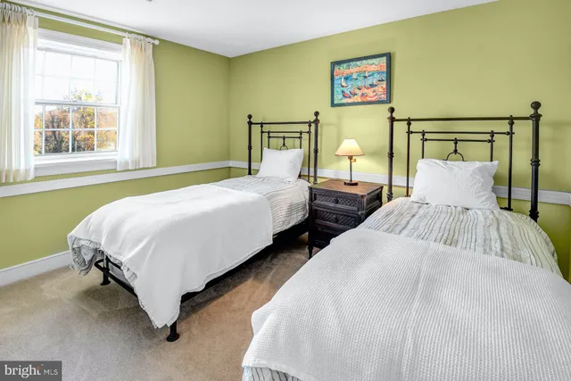 a bedroom with two beds and window