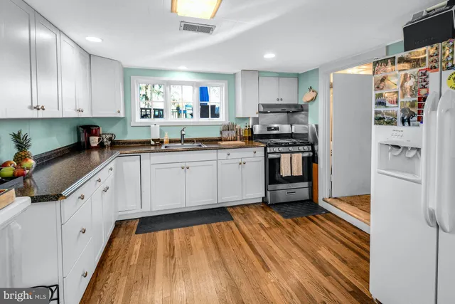 a kitchen with granite countertop stainless steel appliances a sink and cabinets