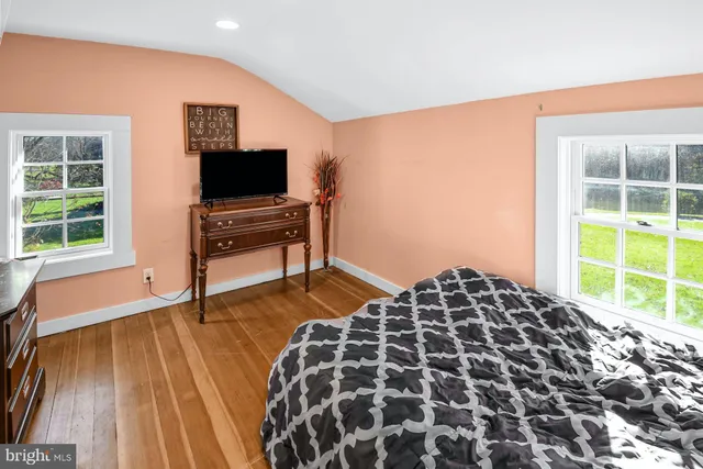 a bedroom with a bed and a flat tv screen next to a window
