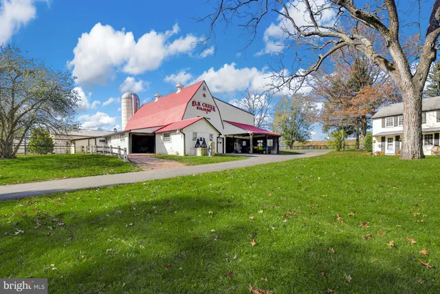 a view of a house with a big yard and large trees