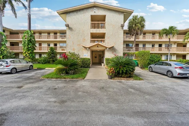 a front view of a residential apartment building with a yard