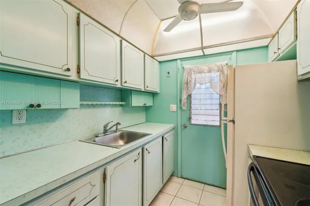 a kitchen with a sink a refrigerator and cabinets