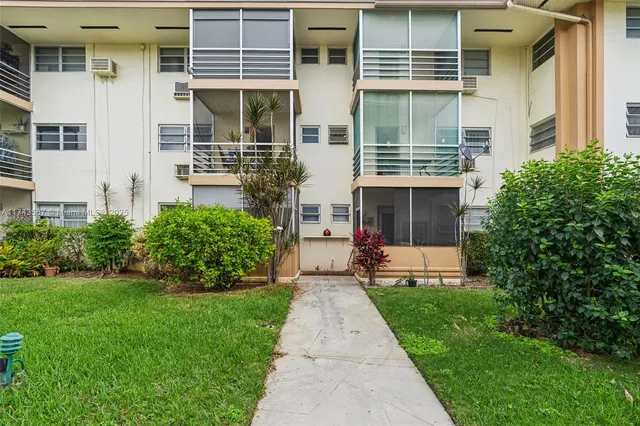 front view of a house with a yard and potted plants