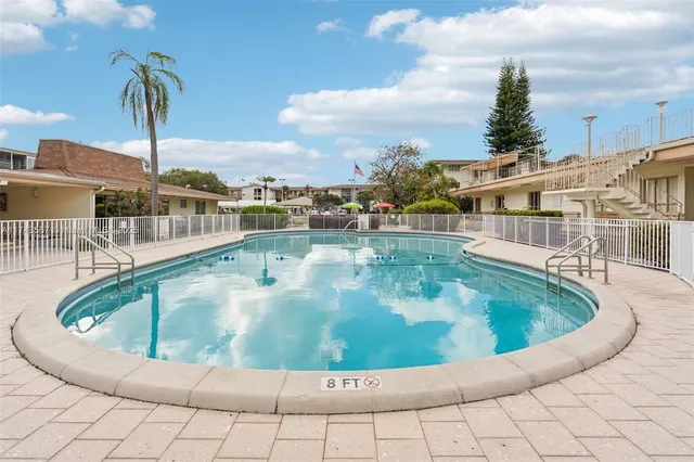 a front view of a house with a garden and lake view