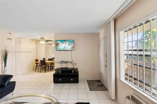 a living room with furniture a dining table and a refrigerator