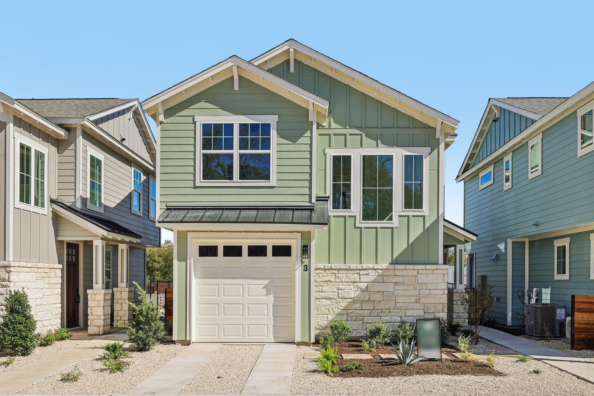 Craftsman inspired home with board and batten siding, stone siding, a garage, and a metal roof