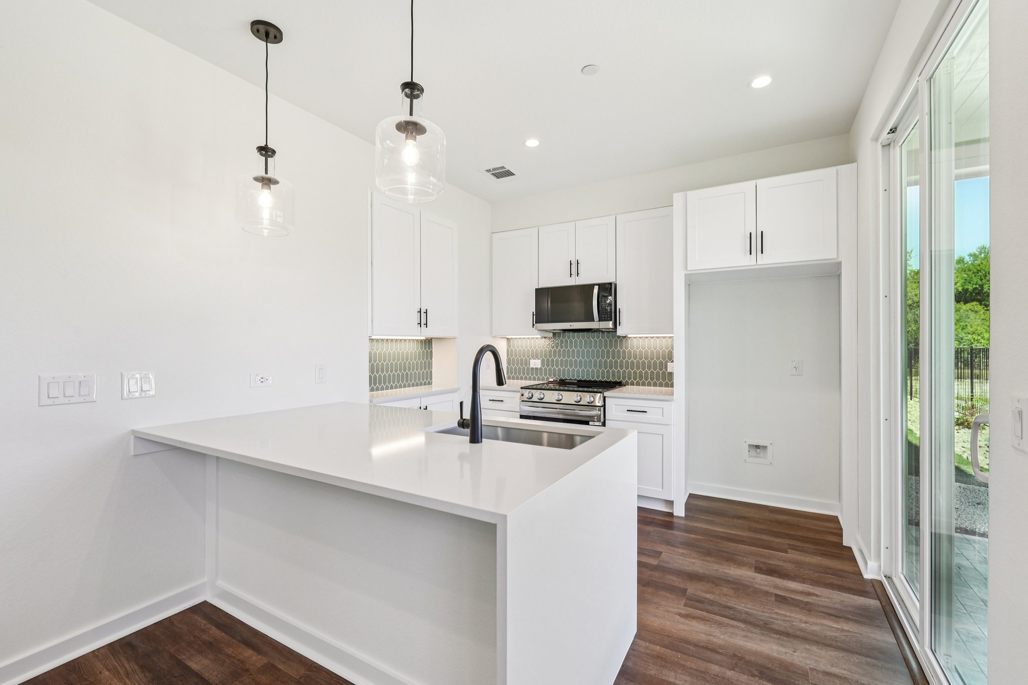 2414 Drew Lane, Unit 3 Austin, TX 78748 - Photo 7 of 18 Kitchen featuring white cabinetry, pendant lighting, a peninsula, stainless steel appliances, and dark wood-type flooring