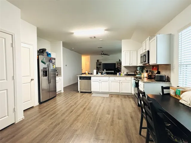 a kitchen with white cabinets and stainless steel appliances
