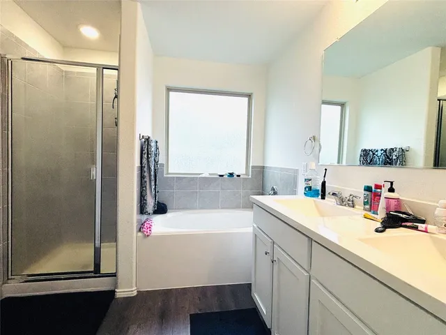 a bathroom with a tub sink and mirror