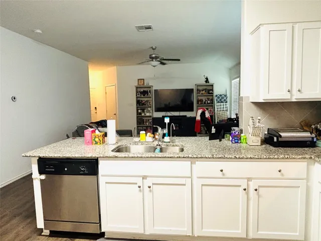 a kitchen with granite countertop a sink stainless steel appliances and cabinets