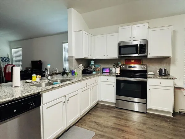 a kitchen with appliances a sink and cabinets