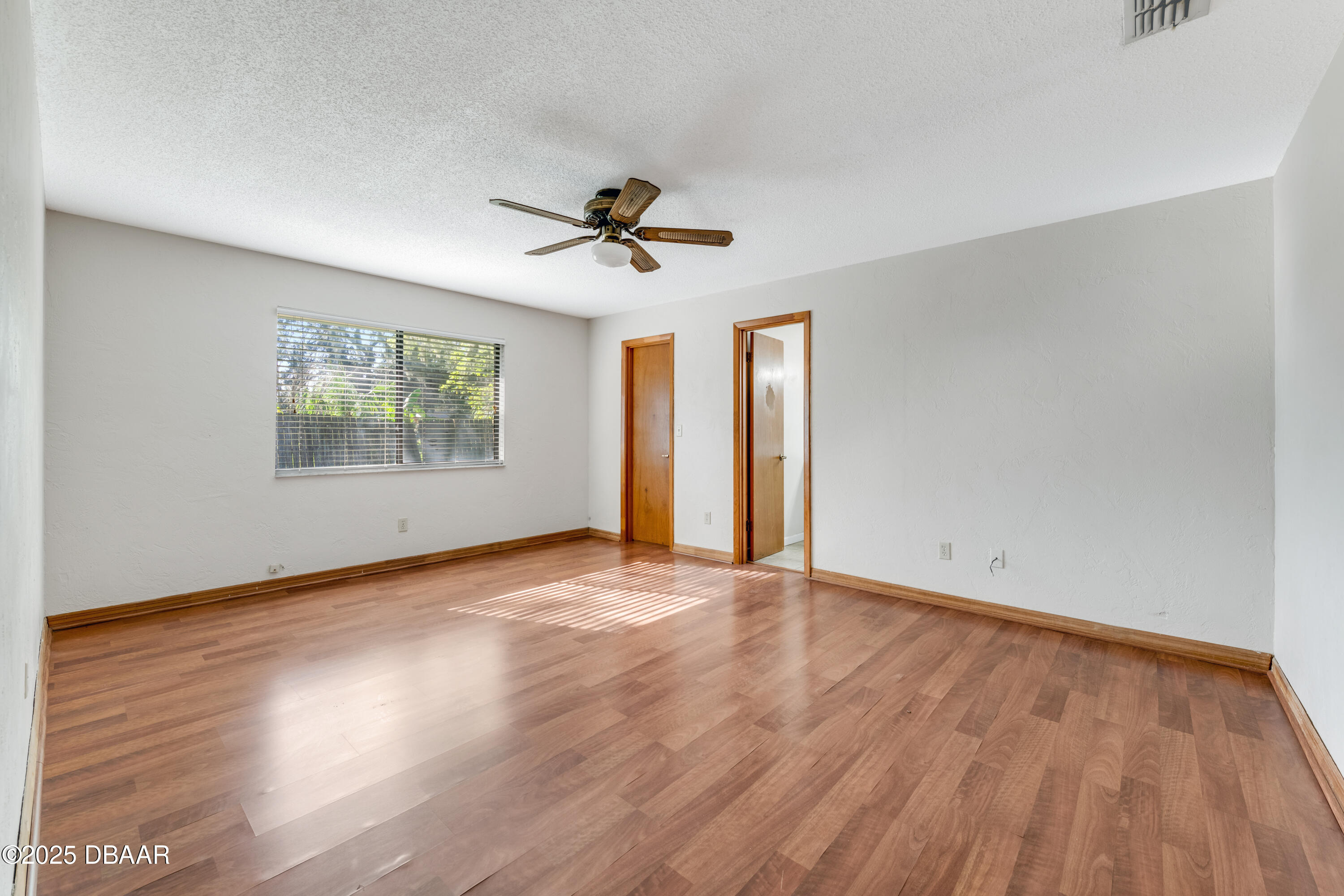 500 Sandy Oaks Boulevard Ormond Beach, FL 32174 - Photo 12 of 31 a view of an empty room with wooden floor and a window