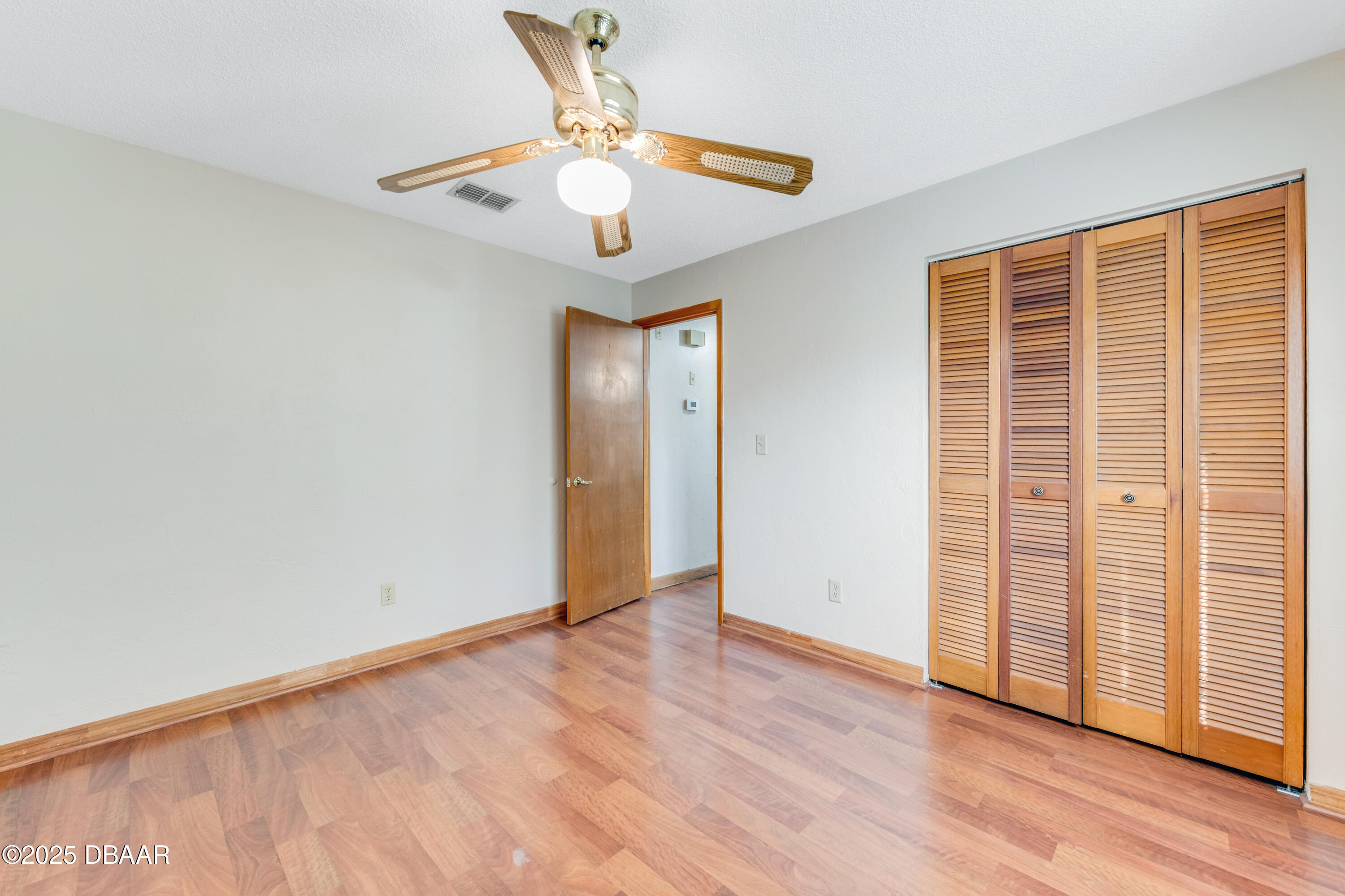 500 Sandy Oaks Boulevard Ormond Beach, FL 32174 - Photo 21 of 31 an empty room with wooden floor fan and windows