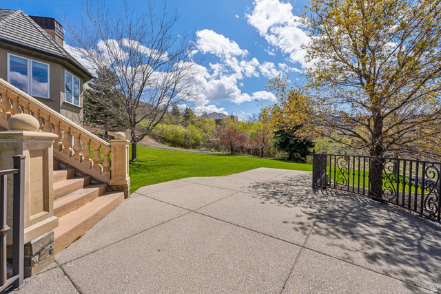1714 Ridge Point Drive Bountiful, UT 84010 - Photo 100 of 132 Concrete patio with decorative wrought iron fencing, stone balustrade staircase, and an expansive lawn