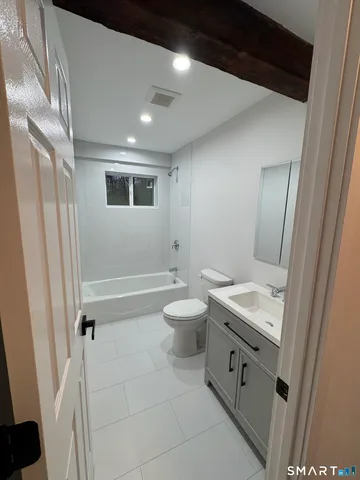 a bathroom with a toilet a sink a mirror and a shower