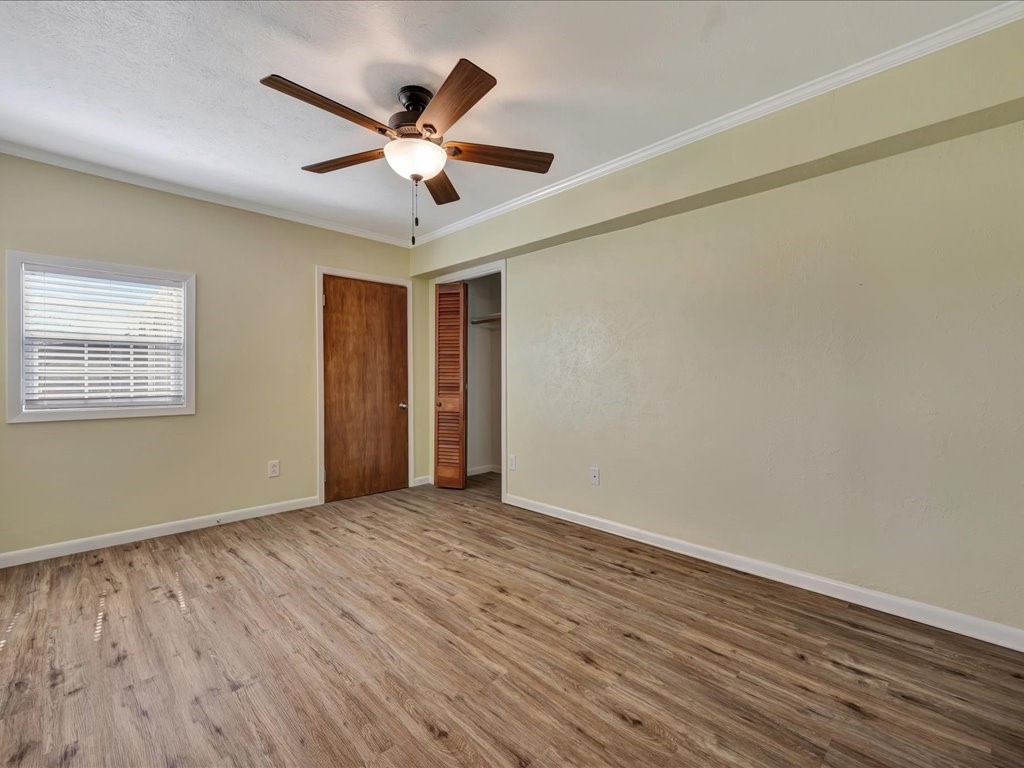 1013 Dewitt Hinson Road Pollok, TX 75969 - Photo 14 of 33 a view of an empty room with wooden floor and a ceiling fan
