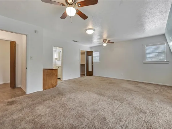 a view of an empty room with a chandelier fan