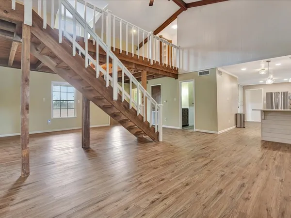 a view of staircase with white walls and wooden floor
