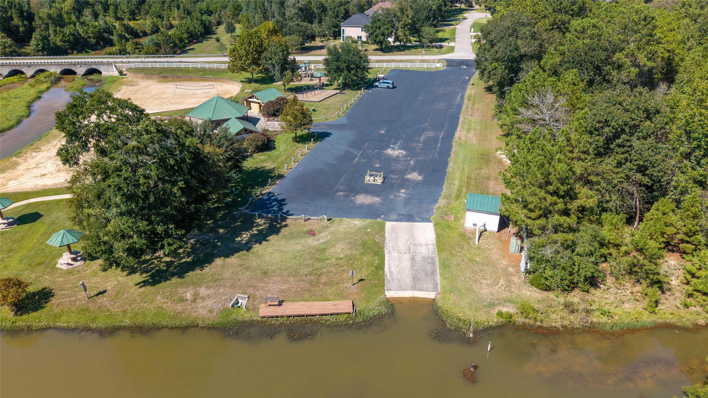 0 Ridgelake Court Montgomery, TX 77316 - Photo 26 of 29 Beautifully situated by a serene waterfront, this property features a spacious paved area with lush greenery, picnic pavilions, and convenient boat ramp access, perfect for outdoor enthusiasts.
