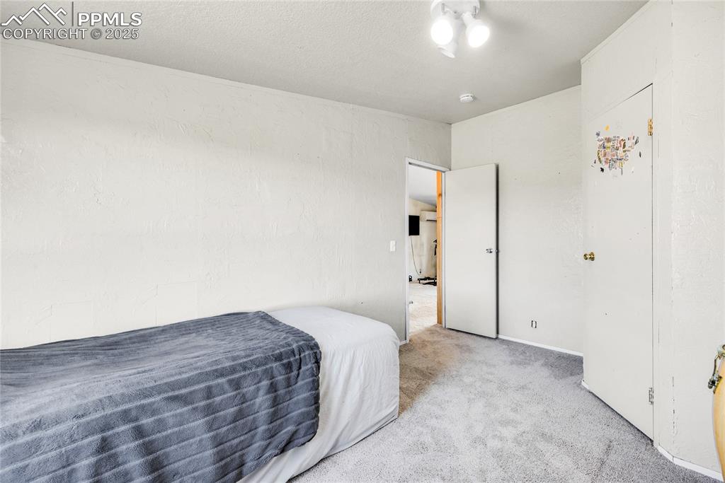 5865 East Blaney Road Peyton, CO 80831 - Photo 28 of 49 a spacious bedroom with a bed and a chandelier