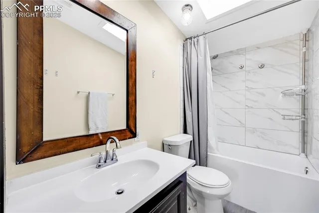 a bedroom with a bed and painting on the wall