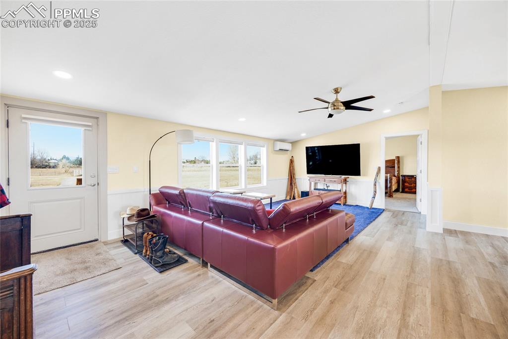 5865 East Blaney Road Peyton, CO 80831 - Photo 6 of 49 a living room with furniture a flat screen tv and a wooden floor