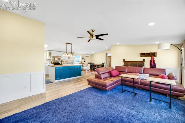 a living room with furniture kitchen view and a wooden floor