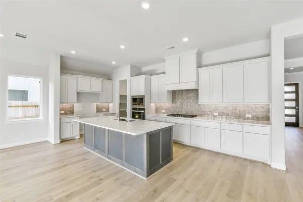 a kitchen with kitchen island a sink stove and refrigerator