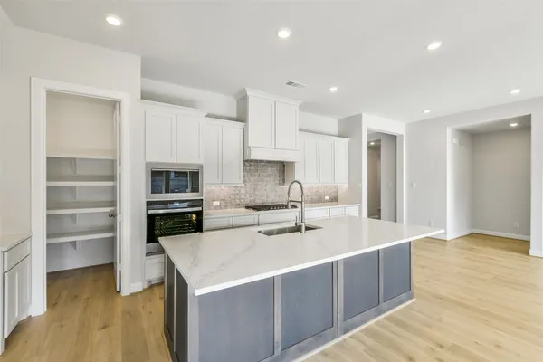 a kitchen with white cabinets and a stove