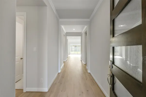 a view of a hallway with wooden floor