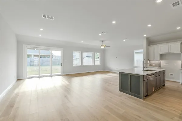 a large kitchen with stainless steel appliances granite countertop a large counter top and a wooden floors