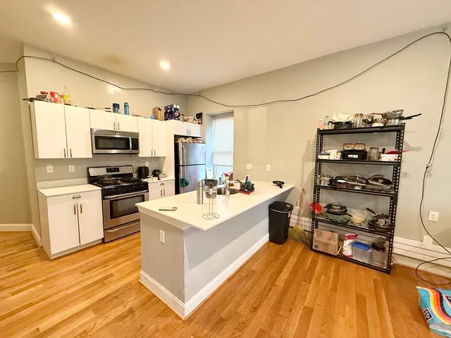 a kitchen with stainless steel appliances a stove top oven a sink and a refrigerator