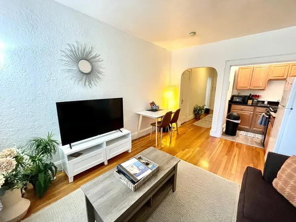 a living room with furniture flat screen tv and a large window